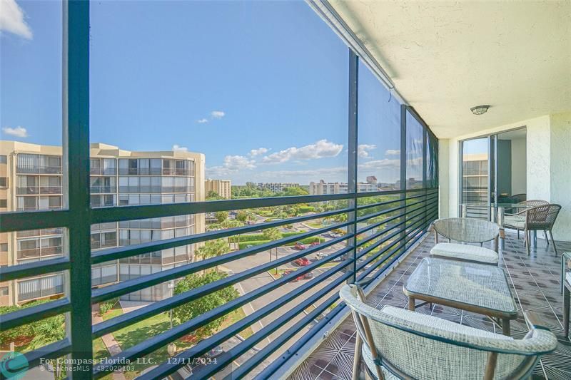 a view of a balcony with chairs and wooden floor