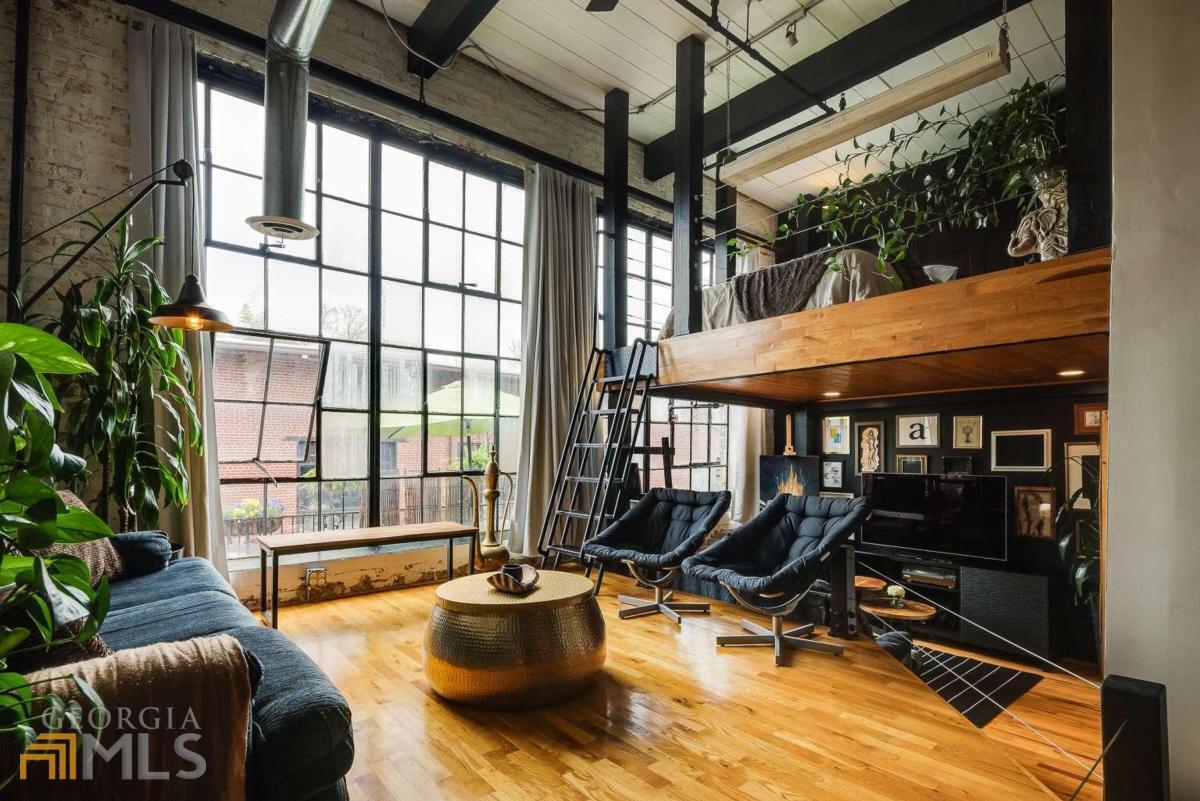 a living room with patio furniture and a potted plant