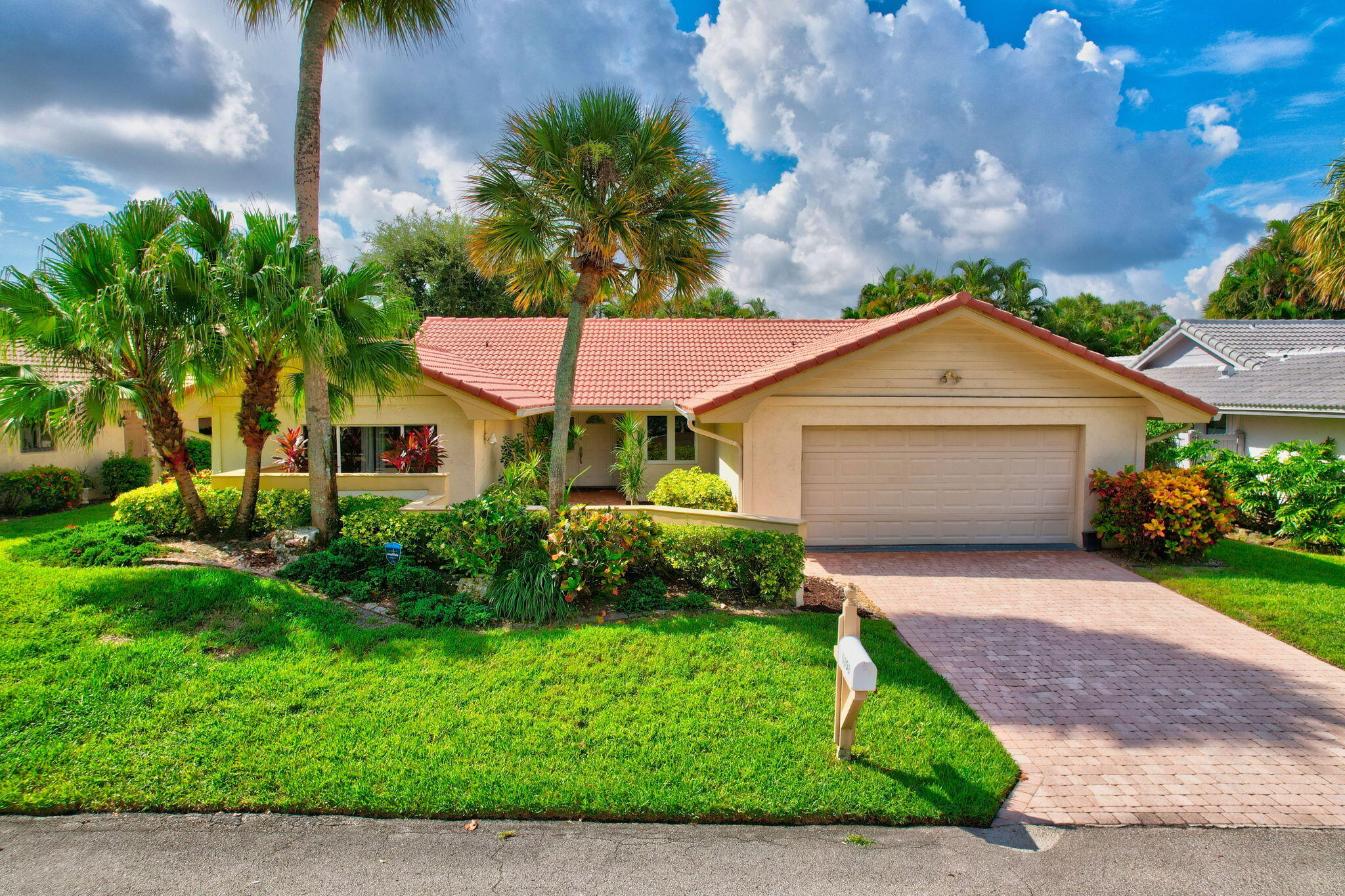 a front view of a house with a yard and potted plants