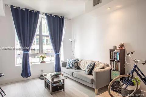 a living room with furniture a window and a flat screen tv