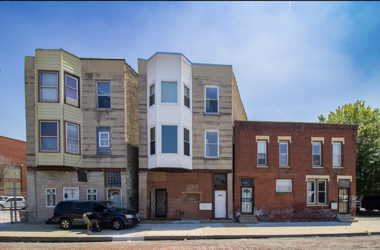 a front view of a residential apartment building with a yard