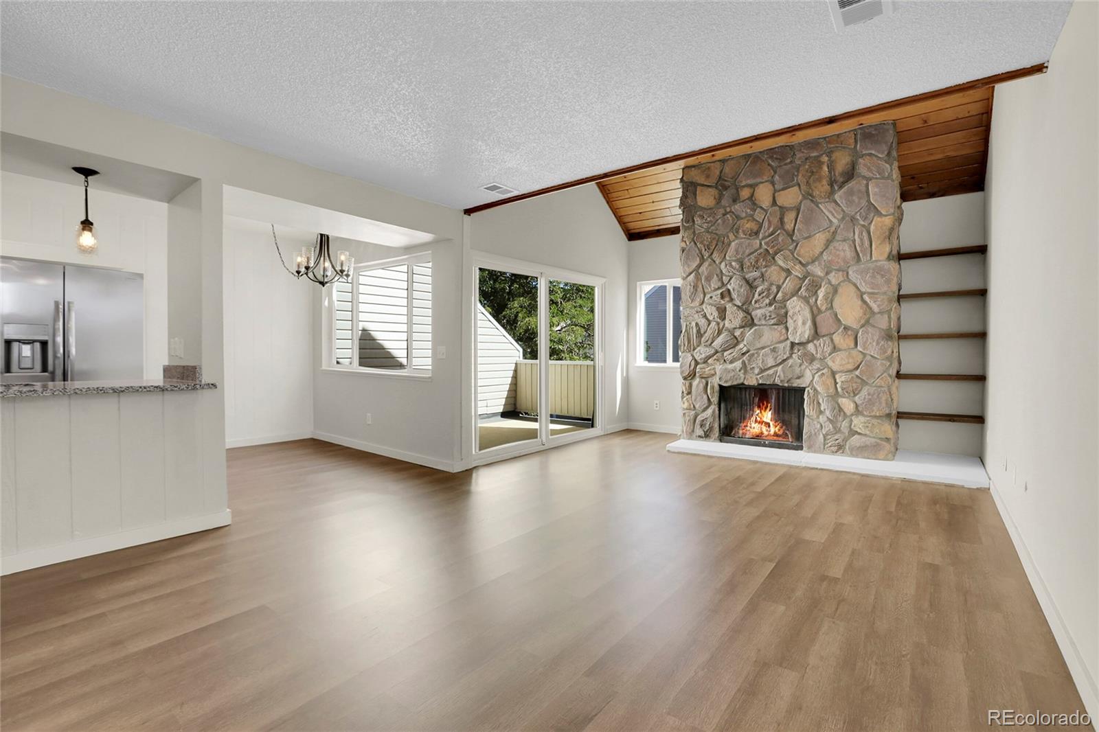 an empty room with wooden floor and fireplace