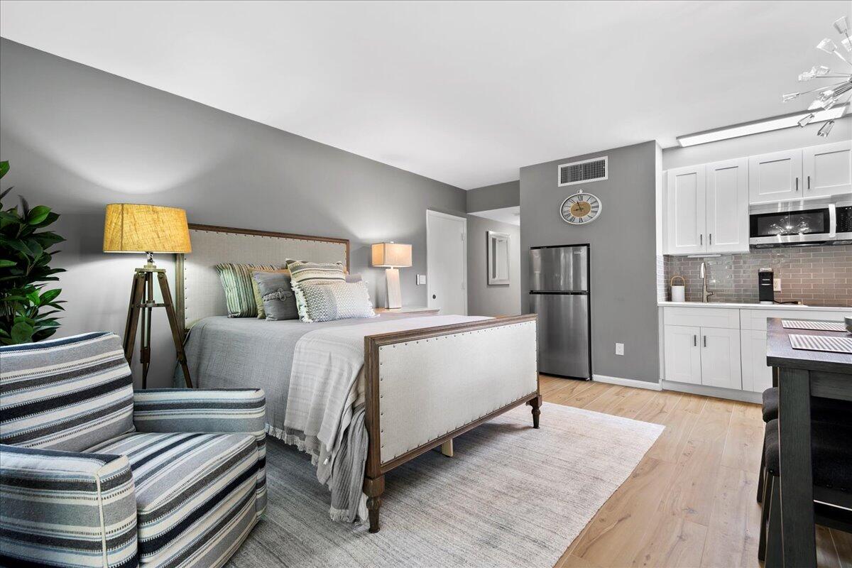 a spacious bedroom with a bed and a view of kitchen