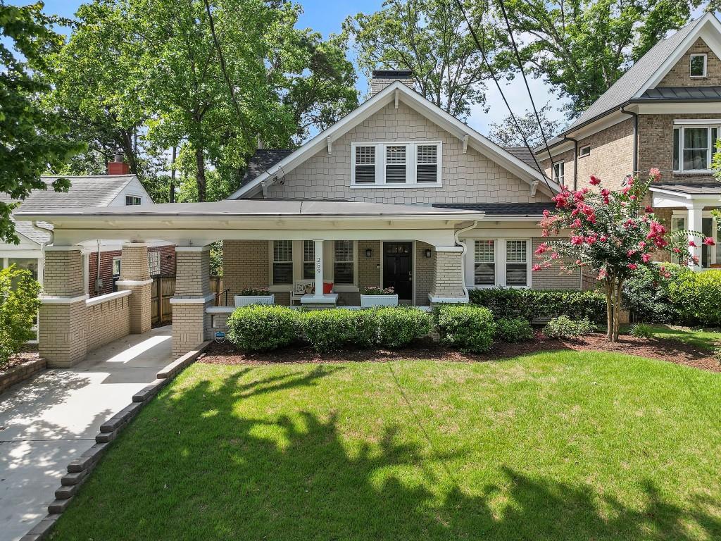 a front view of a house with a yard and potted plants