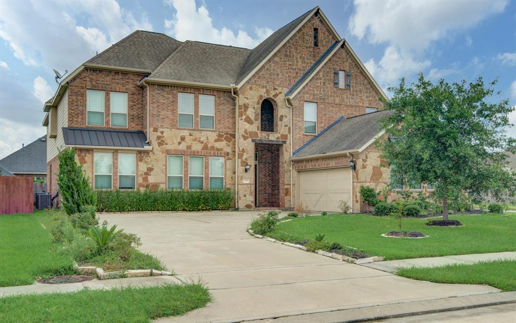 a front view of a house with a yard and potted plants