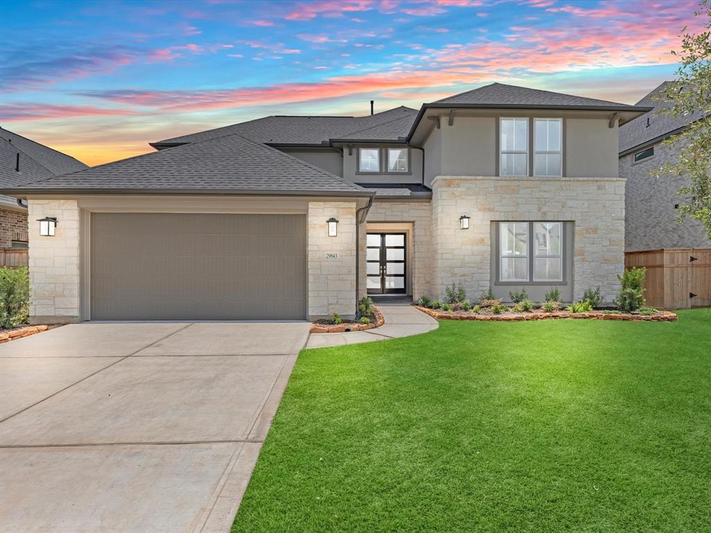 a front view of a house with a garden and yard