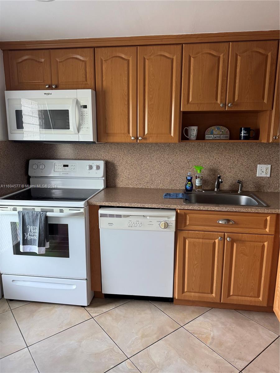 a kitchen with stainless steel appliances granite countertop a sink and a stove