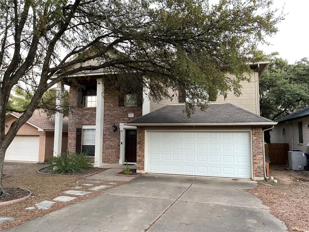 a front view of a house with a tree