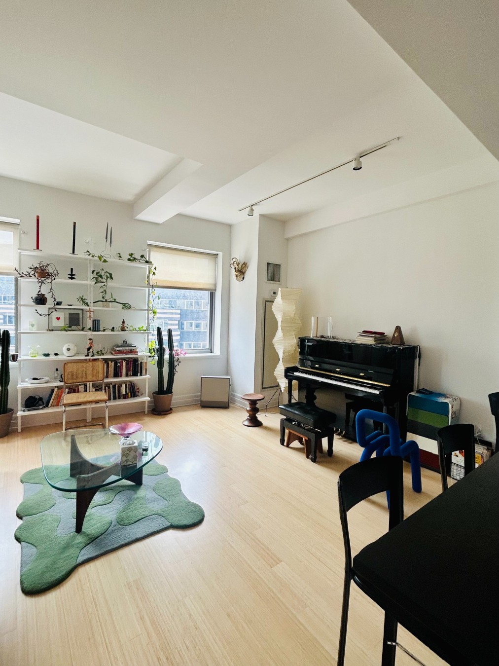 a living room with furniture a piano and wooden floor