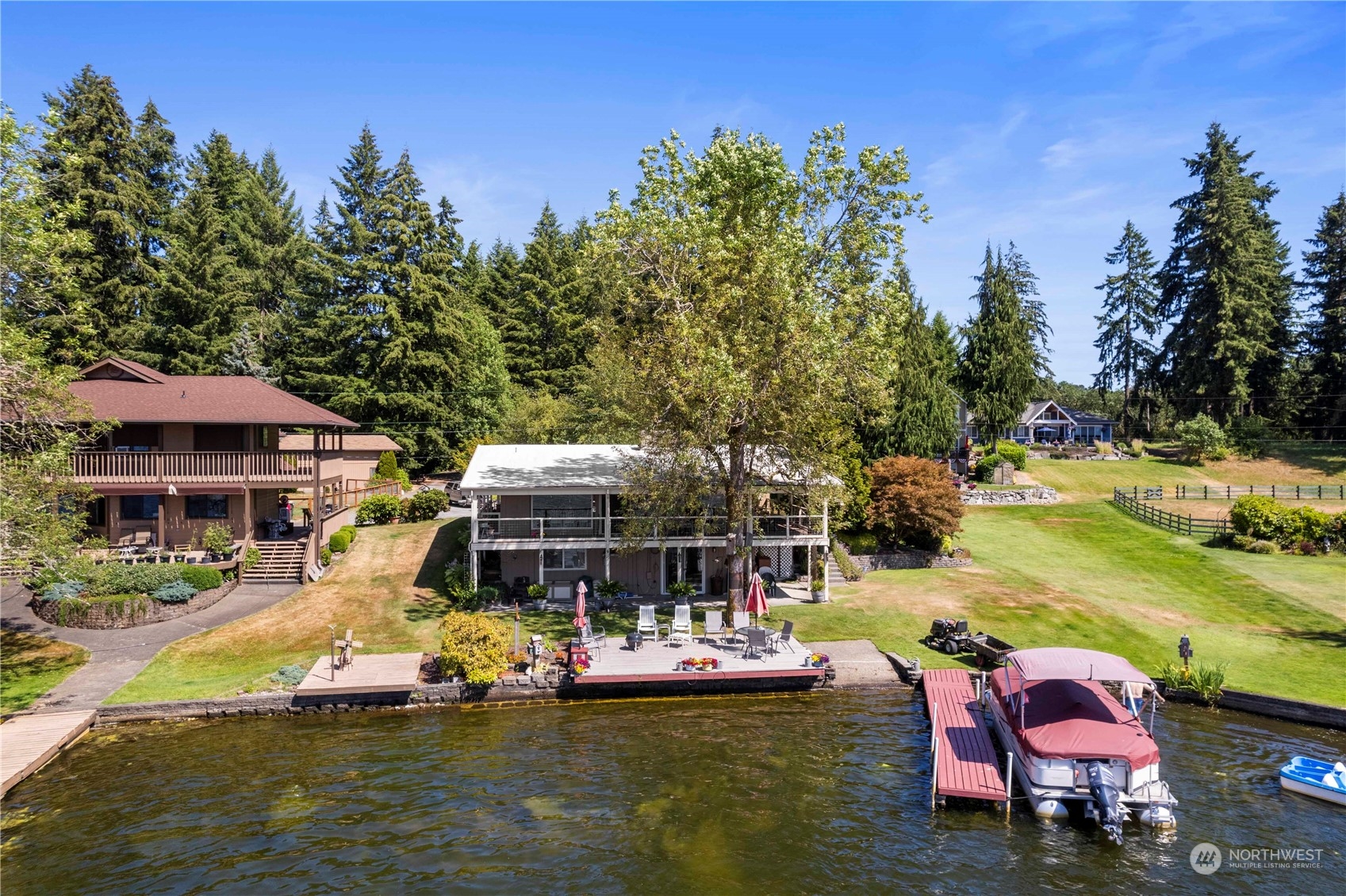 a view of a lake with lawn chairs under an umbrella