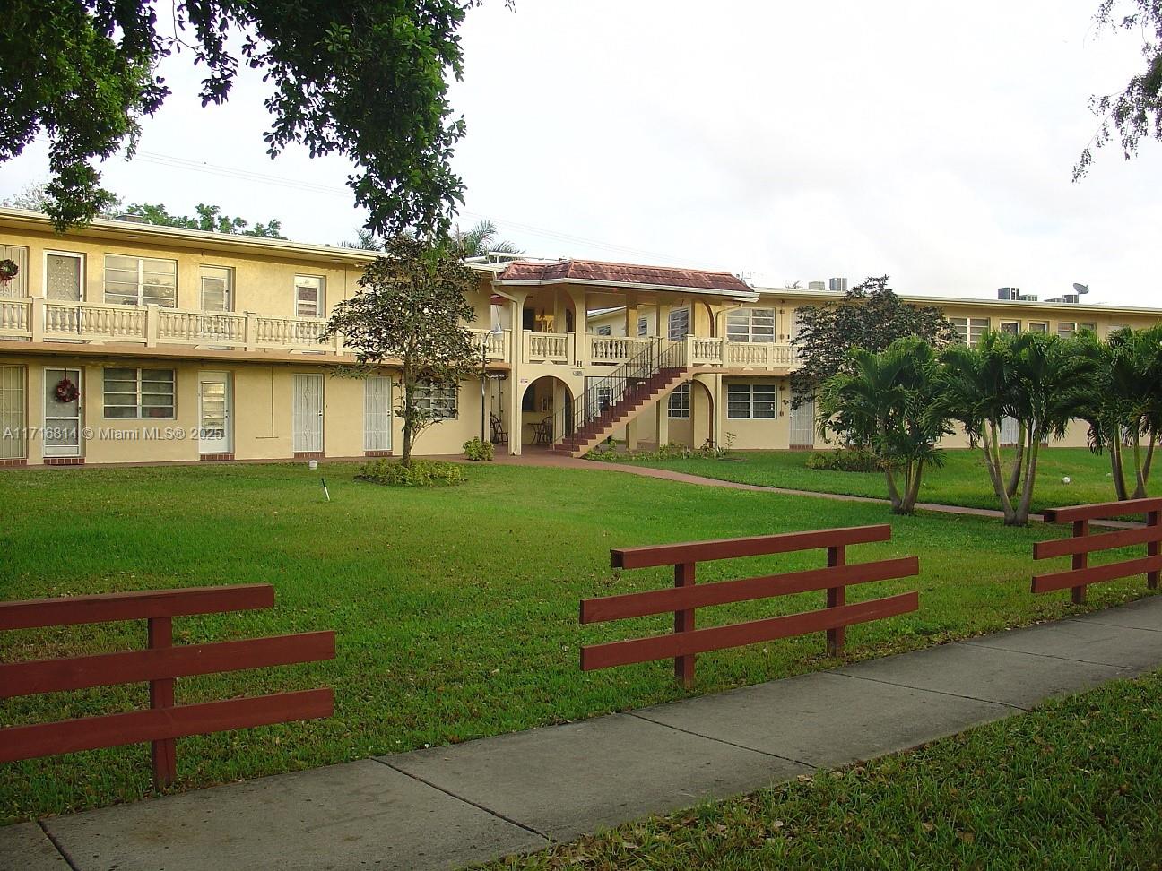 a view of a house with garden and a bench