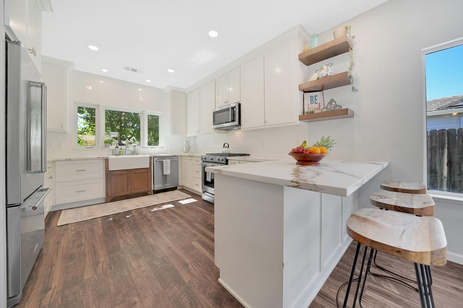 a kitchen with stainless steel appliances granite countertop a sink stove and refrigerator