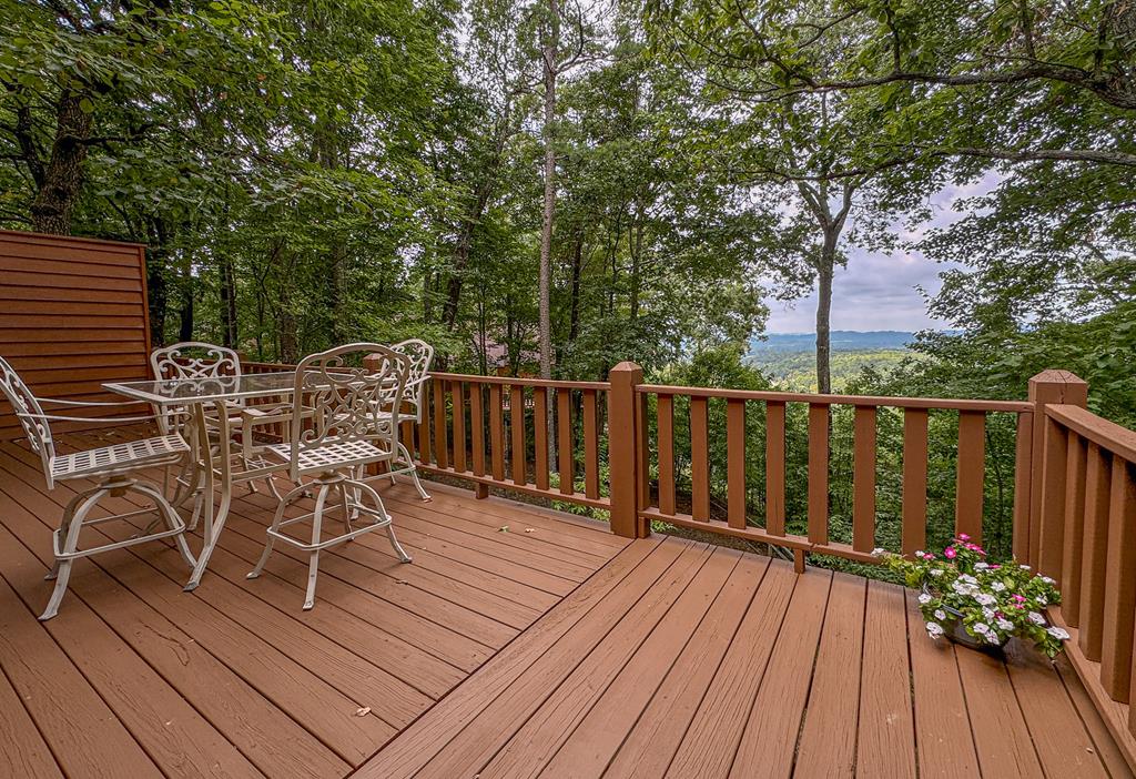 a view of a roof deck with table and chairs and wooden floor