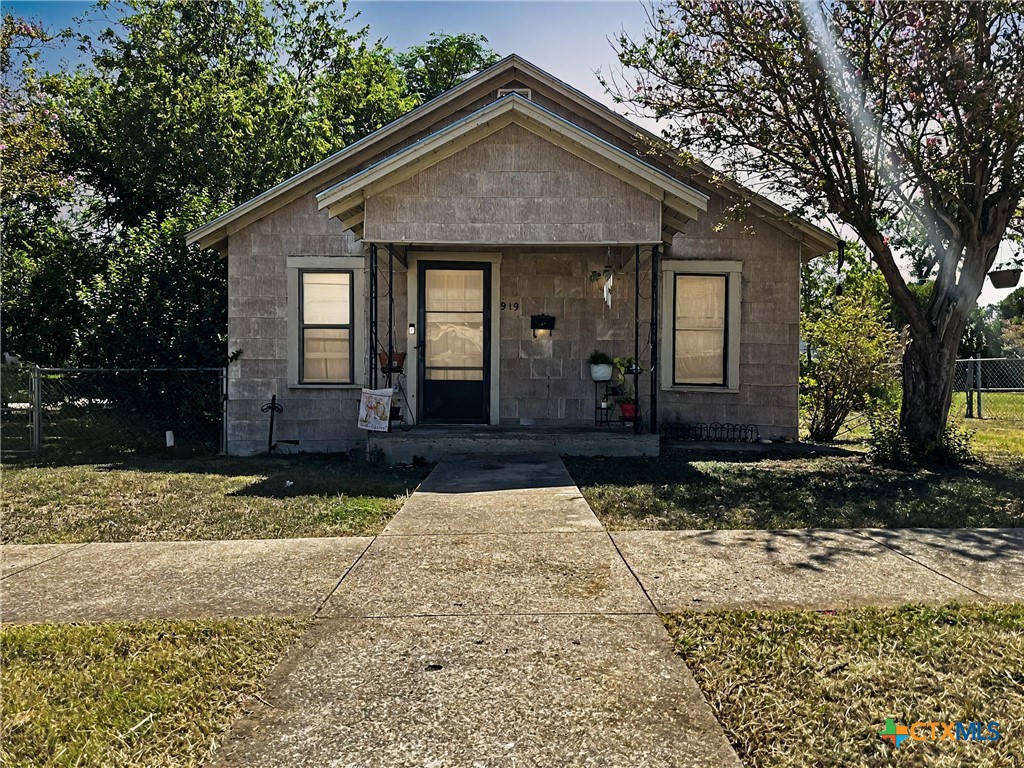 a front view of a house with a yard and trees