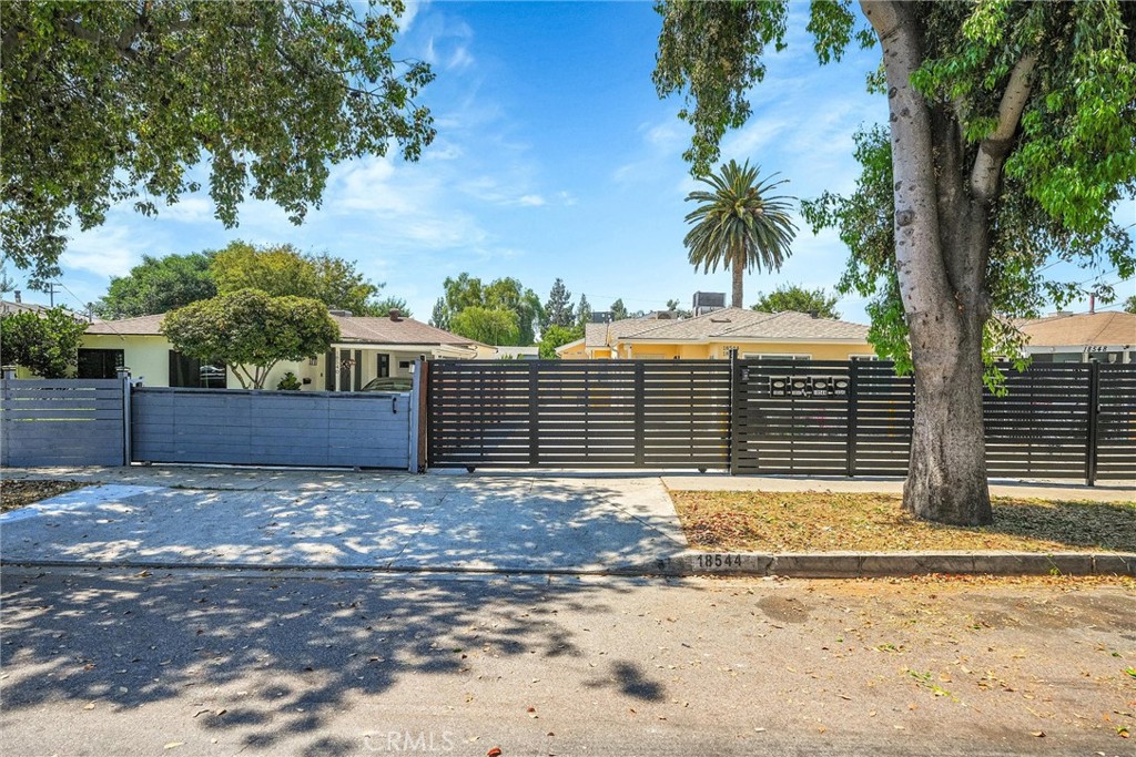 a view of a house with a yard and large tree