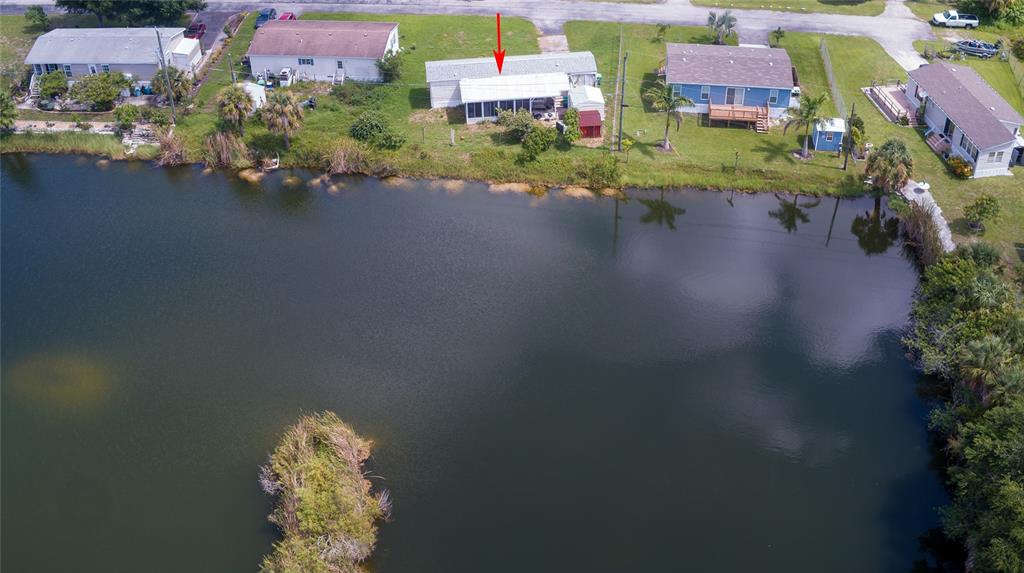 an aerial view of a house with a garden and lake view