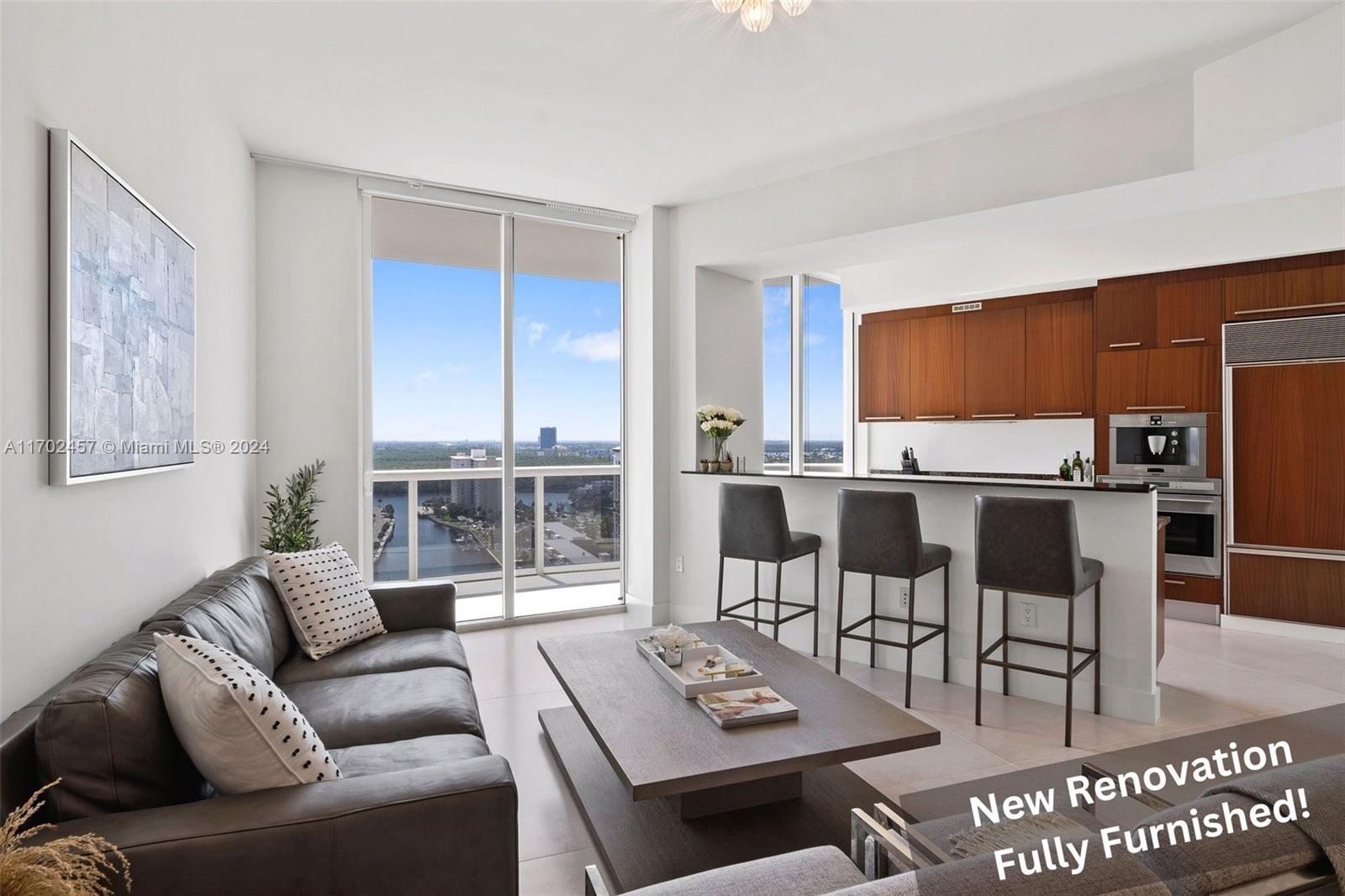 a living room with furniture a rug and kitchen view