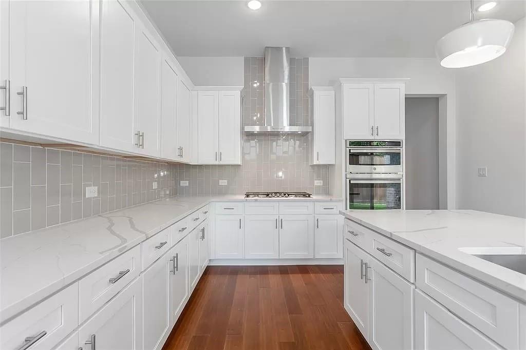 a kitchen with granite countertop white cabinets and appliances