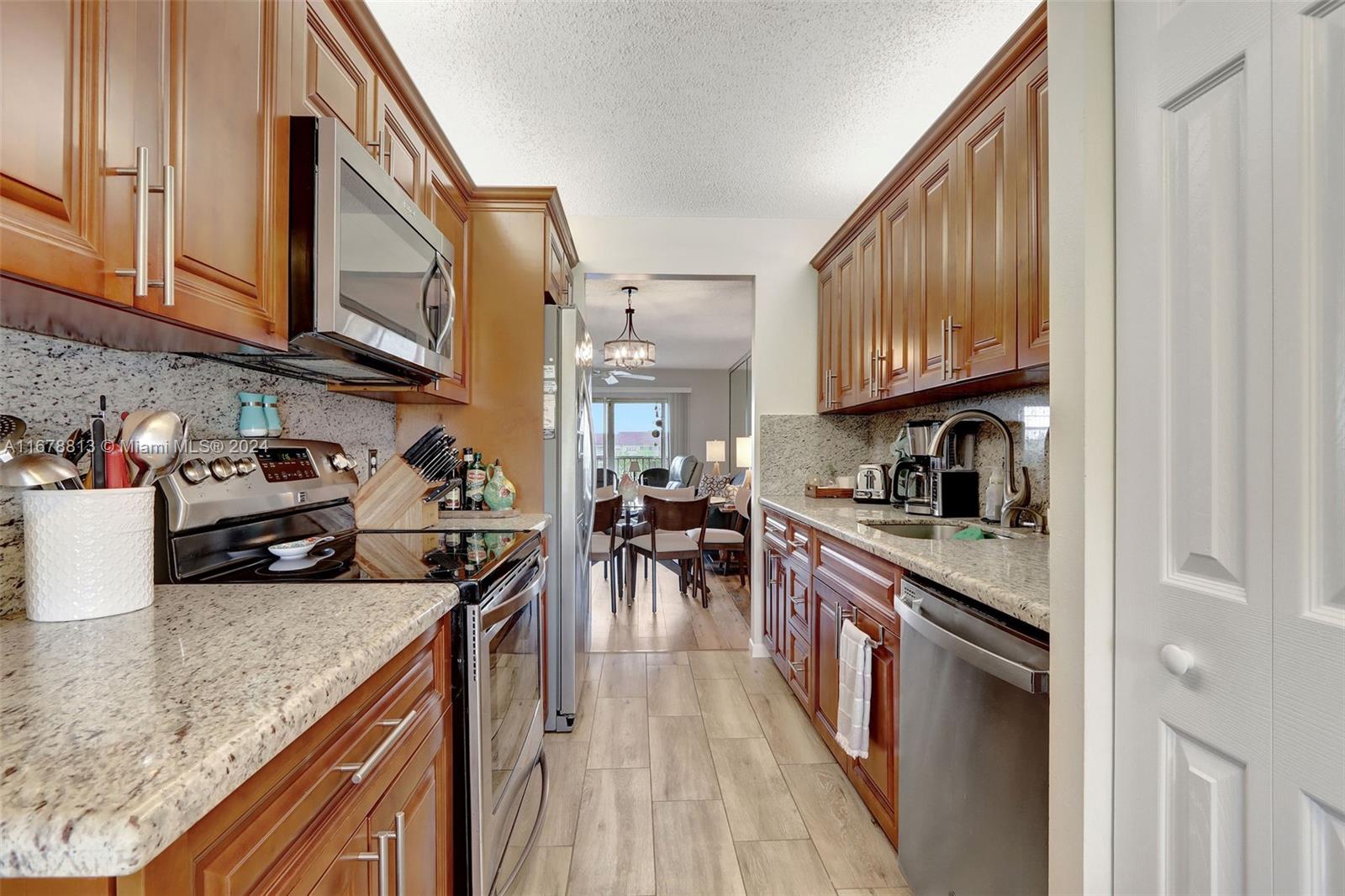 a kitchen with stainless steel appliances granite countertop wooden cabinets a stove top oven a sink and dishwasher