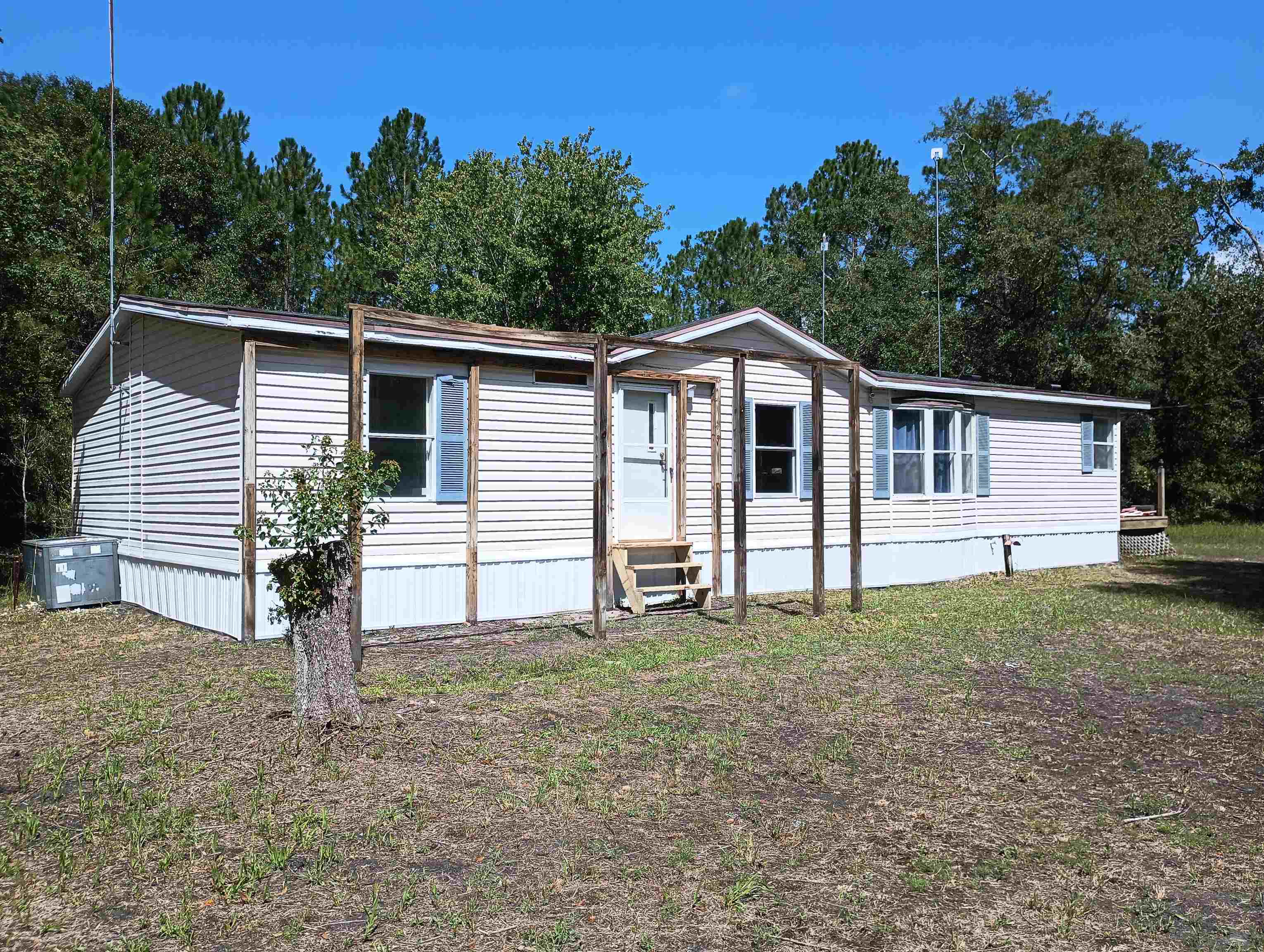 a view of a house with backyard and trees