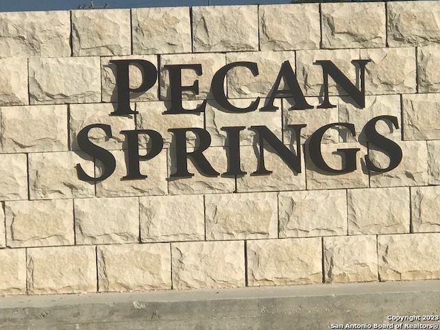 a street sign on a wall next to a road