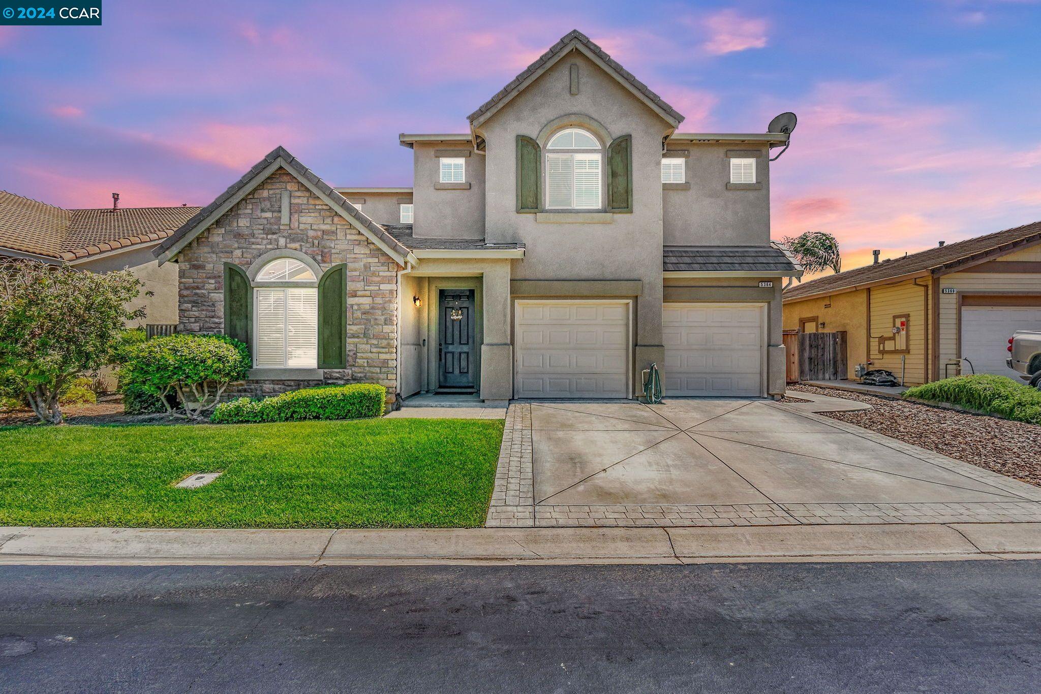 a front view of a house with a yard and garage