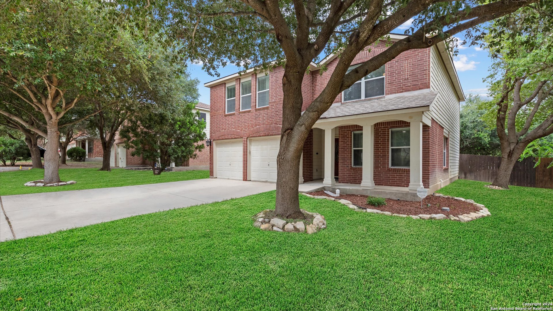 a front view of a house with a yard and trees