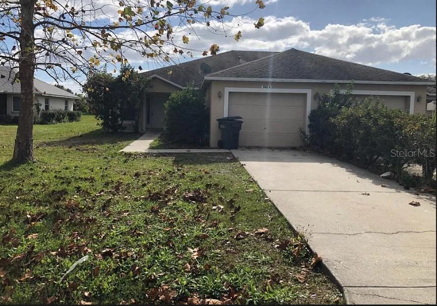 a view of a small white house with a yard