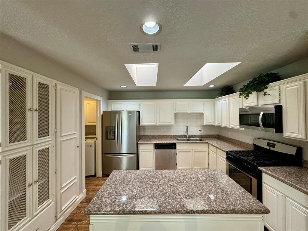 a kitchen with stainless steel appliances granite countertop a refrigerator stove microwave and sink