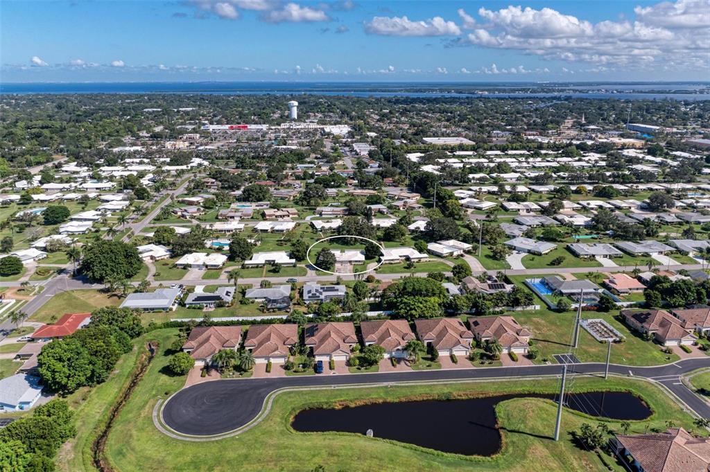 an aerial view of a residential houses with outdoor space and lake view in back