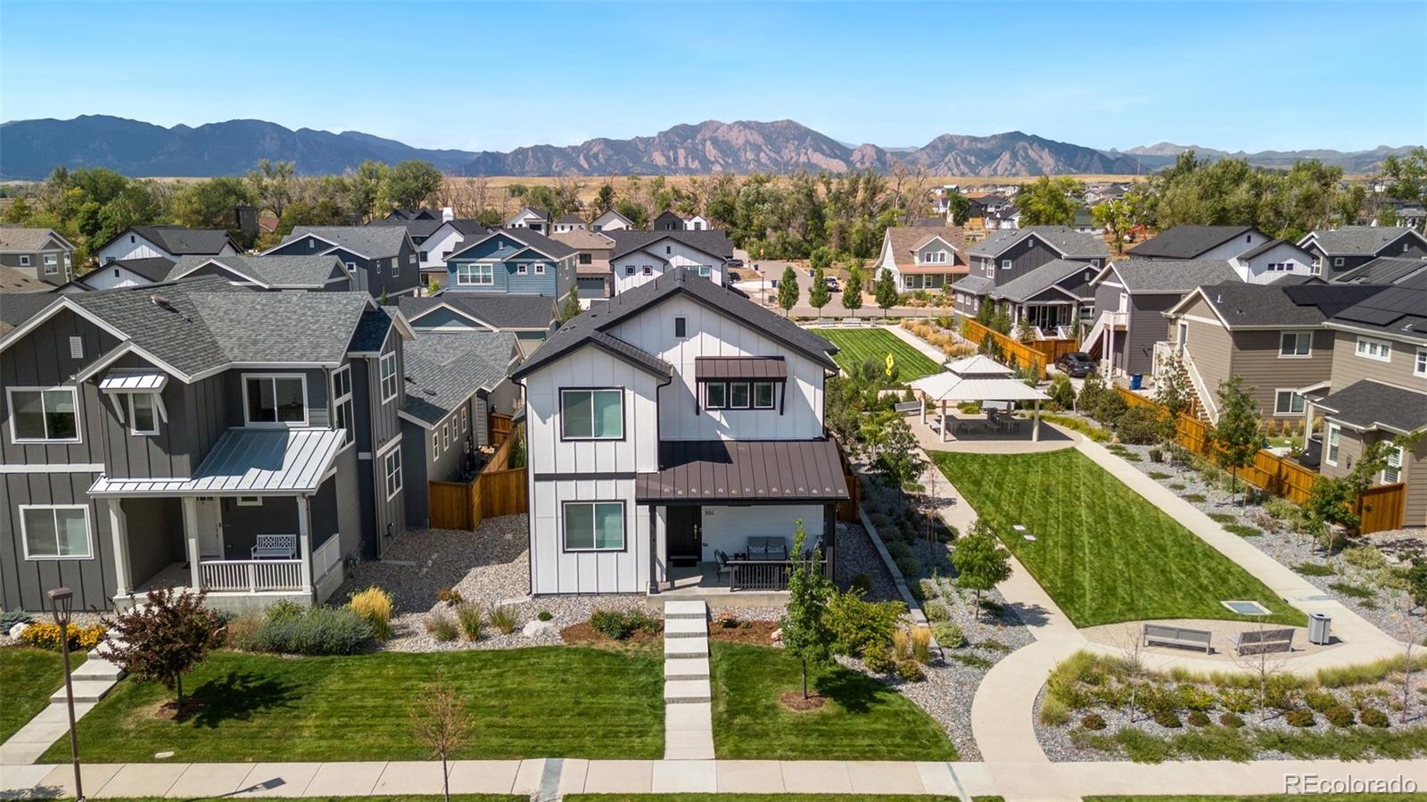 an aerial view of residential houses with outdoor space and trees