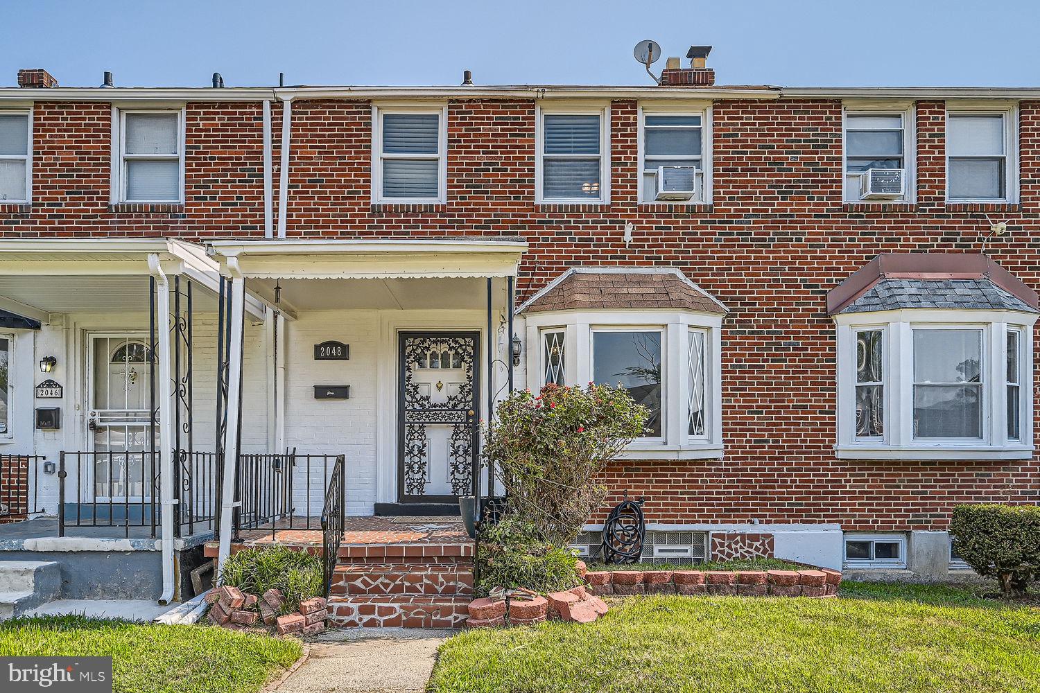 front view of a brick house with a yard