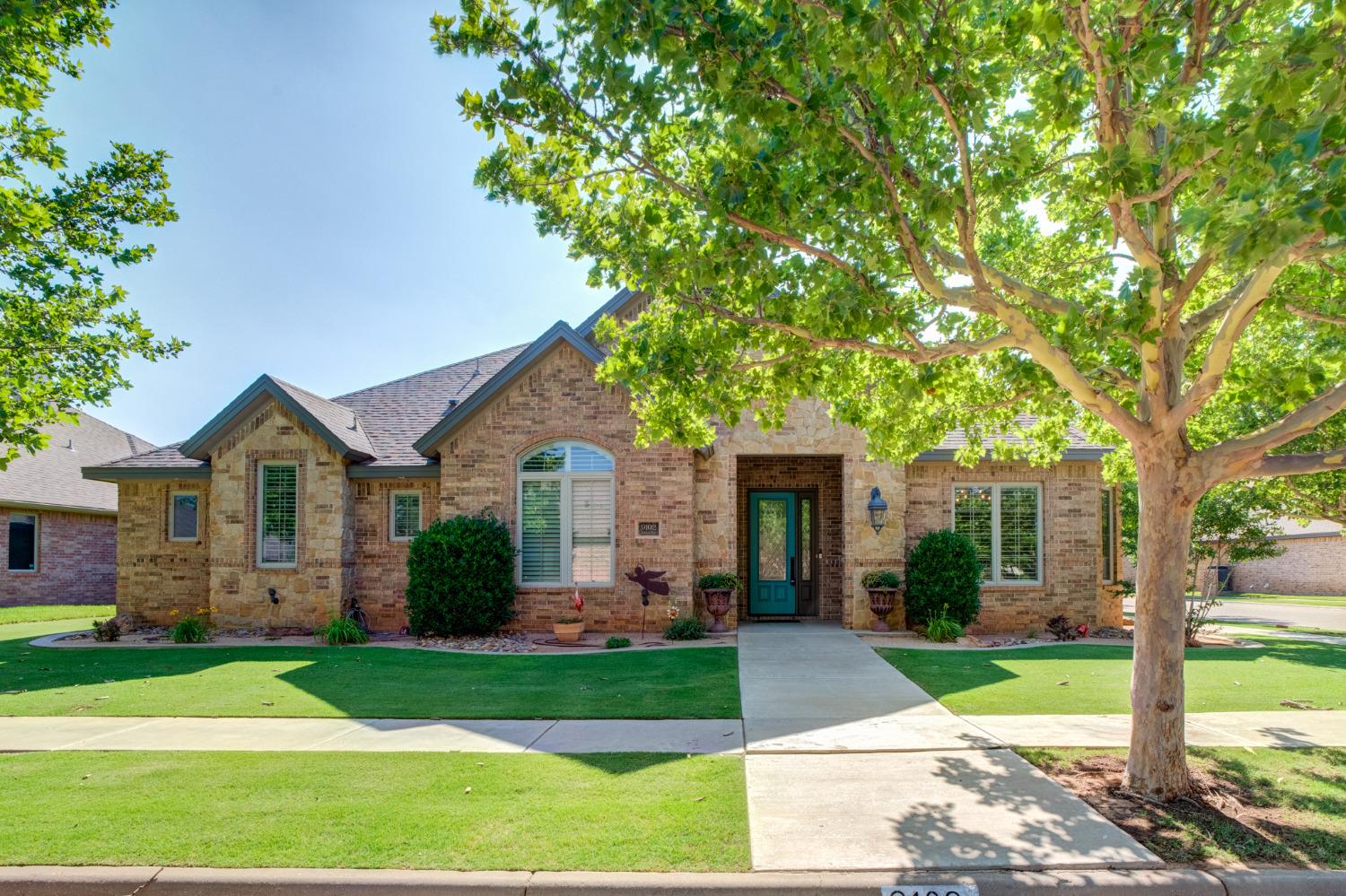 a front view of a house with a yard and potted plants