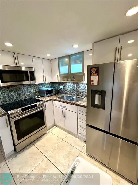 a kitchen with a refrigerator sink and microwave