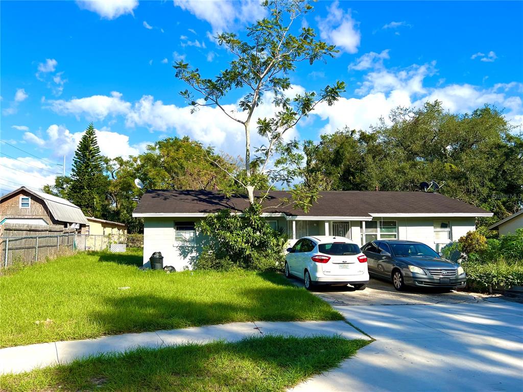 a front view of a house with a garden and car parked