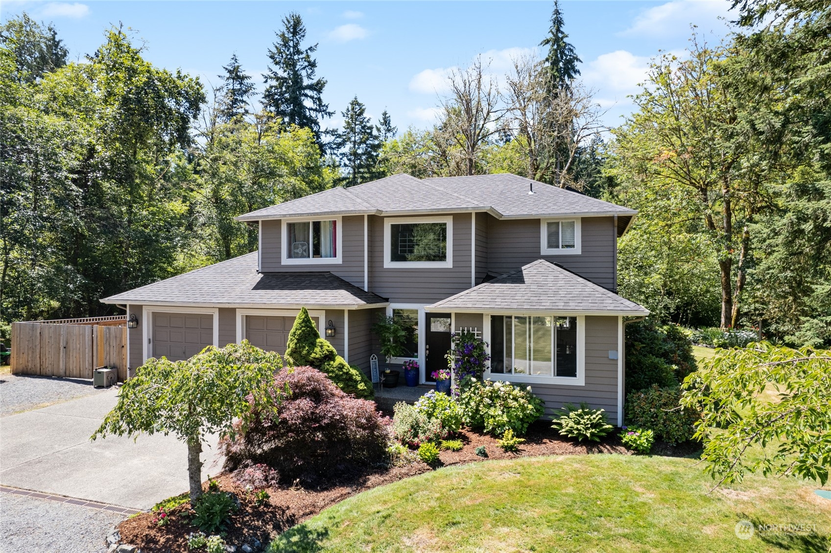 a front view of a house with a yard and trees