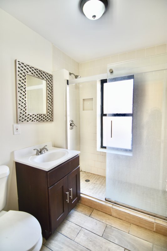 a bathroom with a sink vanity mirror and toilet