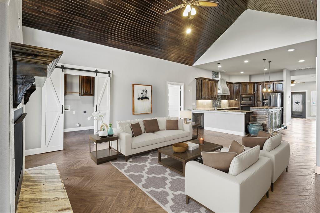 a living room with furniture and a view of kitchen