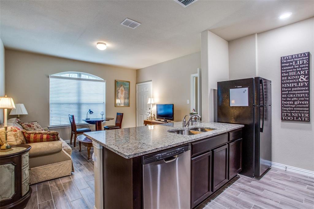 a kitchen with granite countertop a sink and a refrigerator