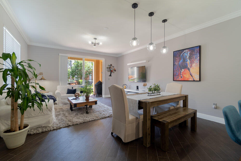 a living room with furniture a potted plant and a large window