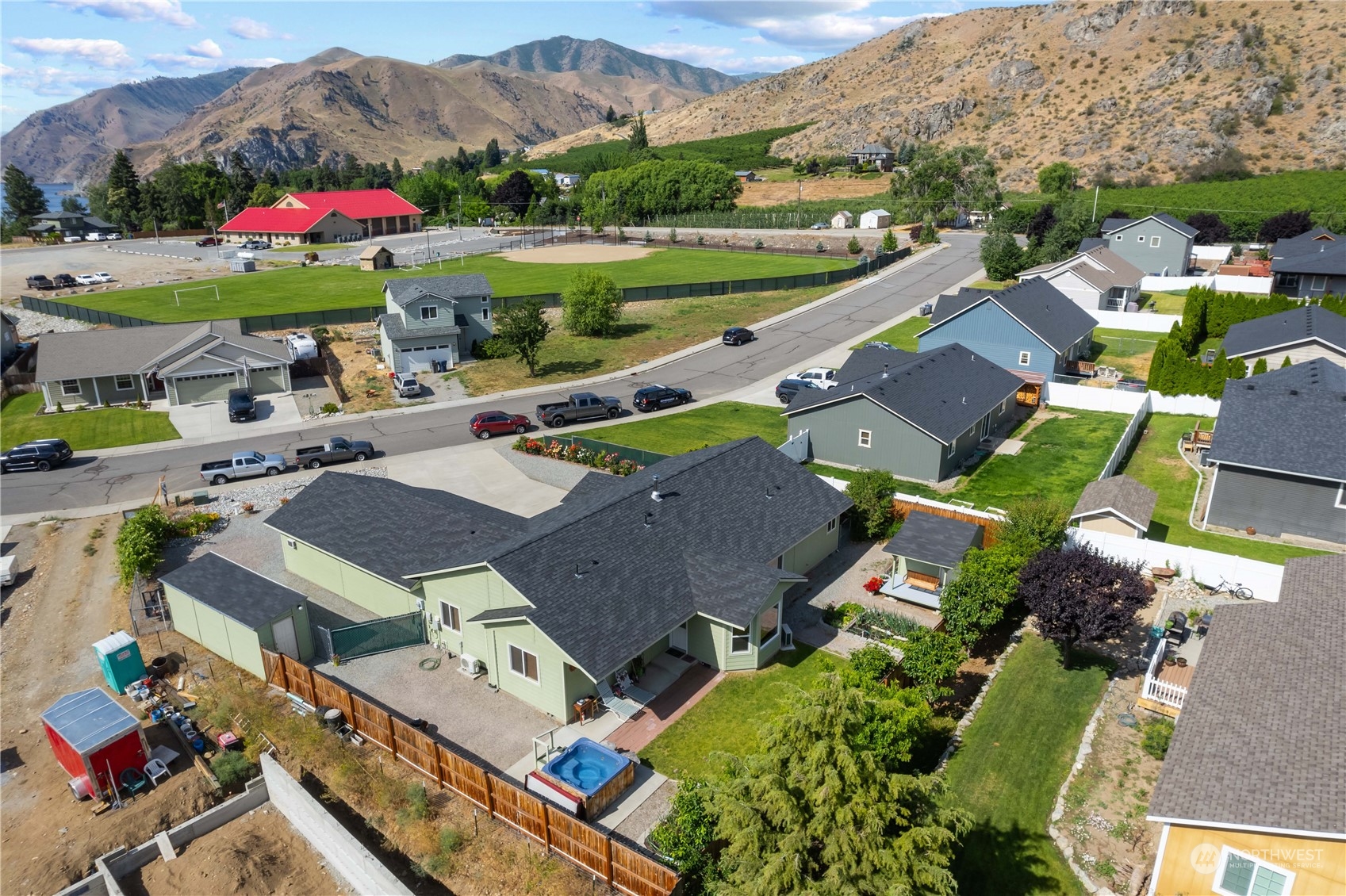 an aerial view of residential houses with outdoor space and parking