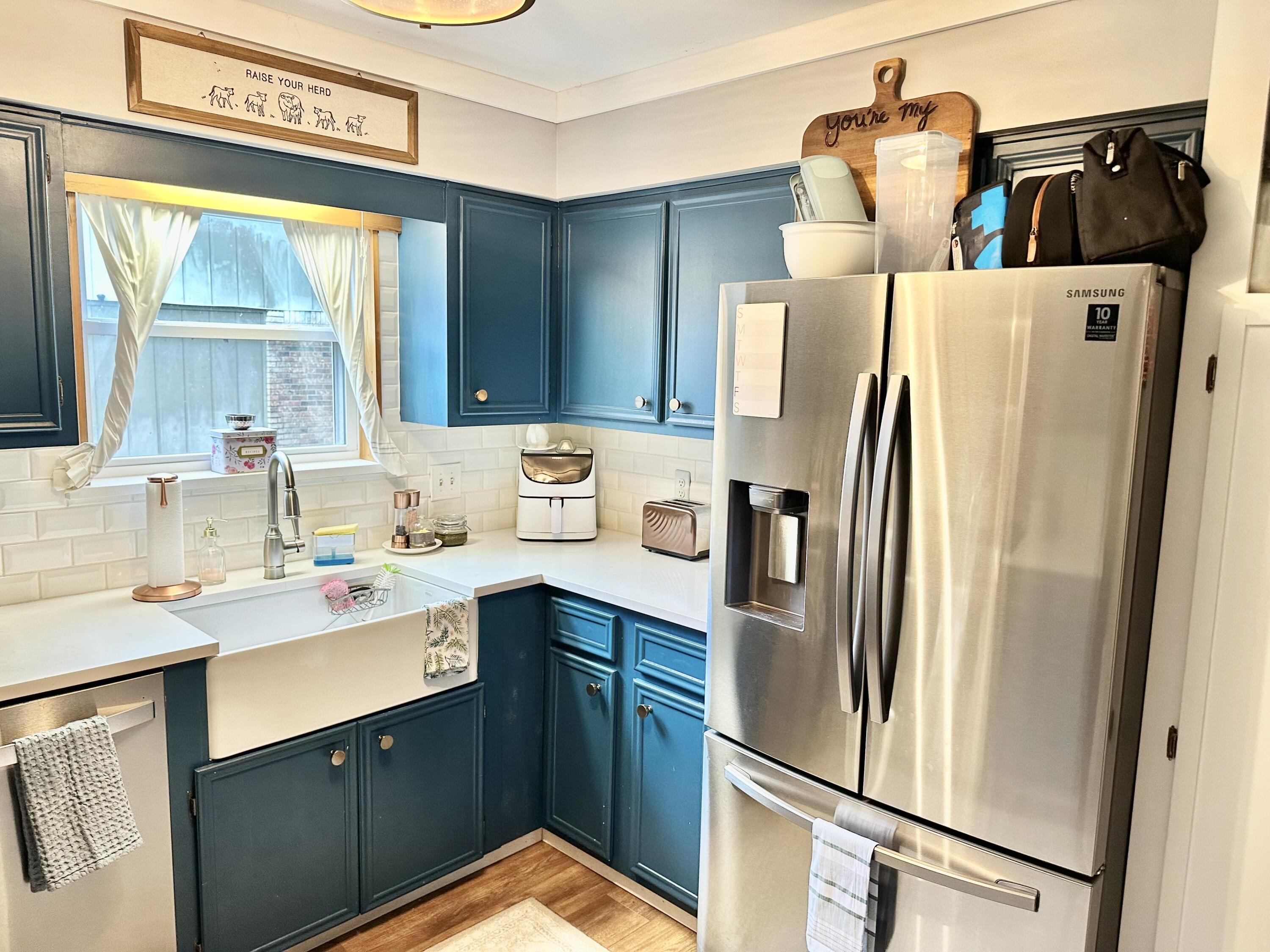 a kitchen with a refrigerator sink and cabinets