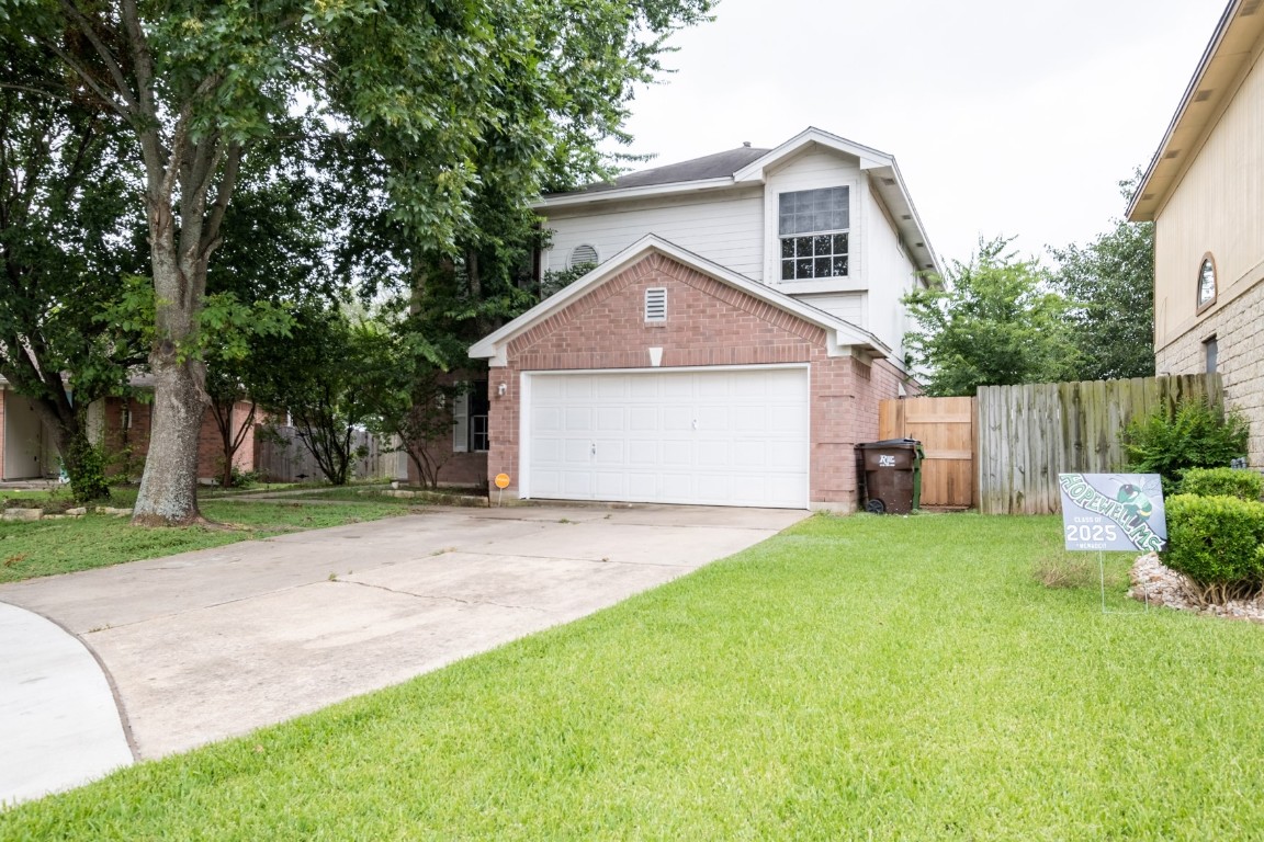 a front view of a house with a yard and trees