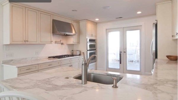 a kitchen with stainless steel appliances granite countertop a refrigerator and a stove top oven