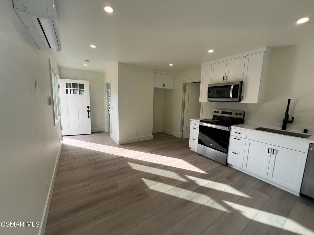 a kitchen with granite countertop a refrigerator and a stove top oven