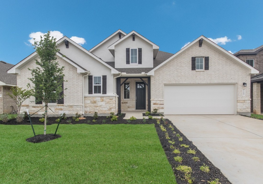 a front view of a house with a yard and trees