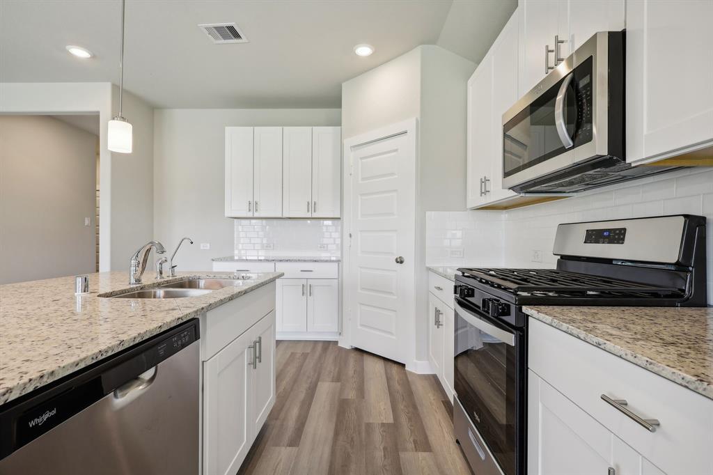 a kitchen with a sink stove and microwave