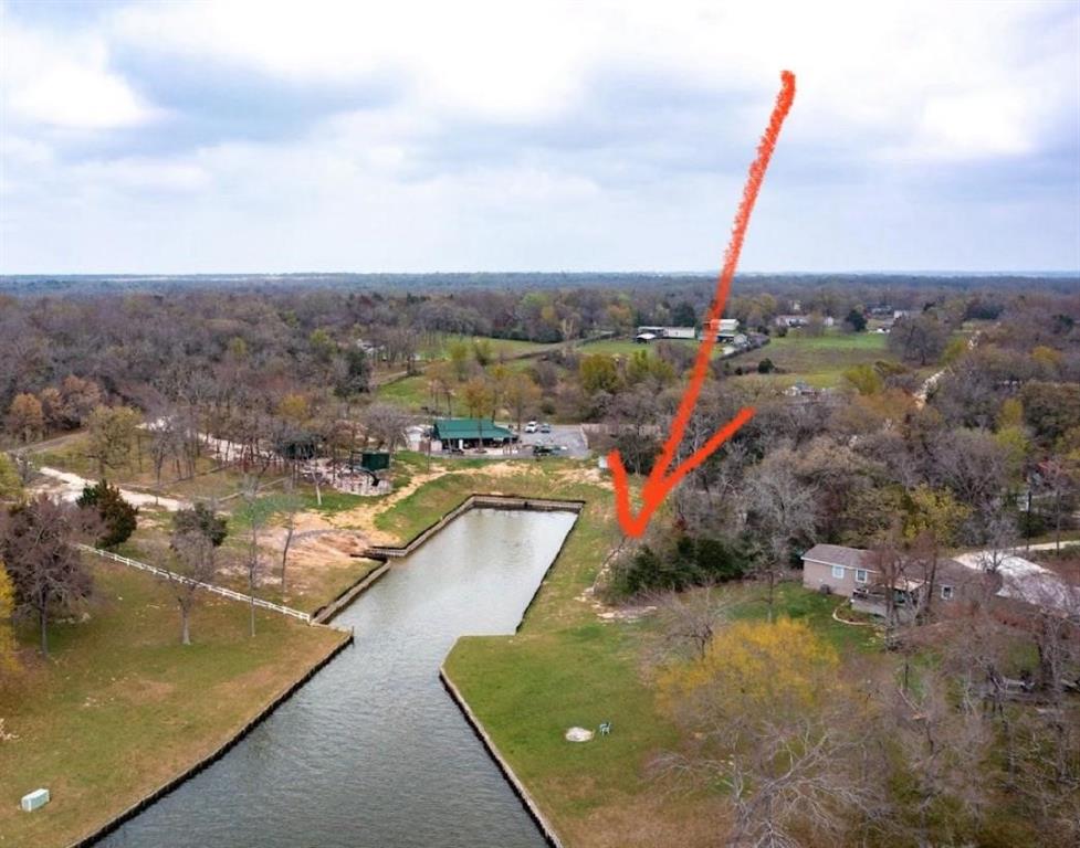 an aerial view of a house with a yard and lake view