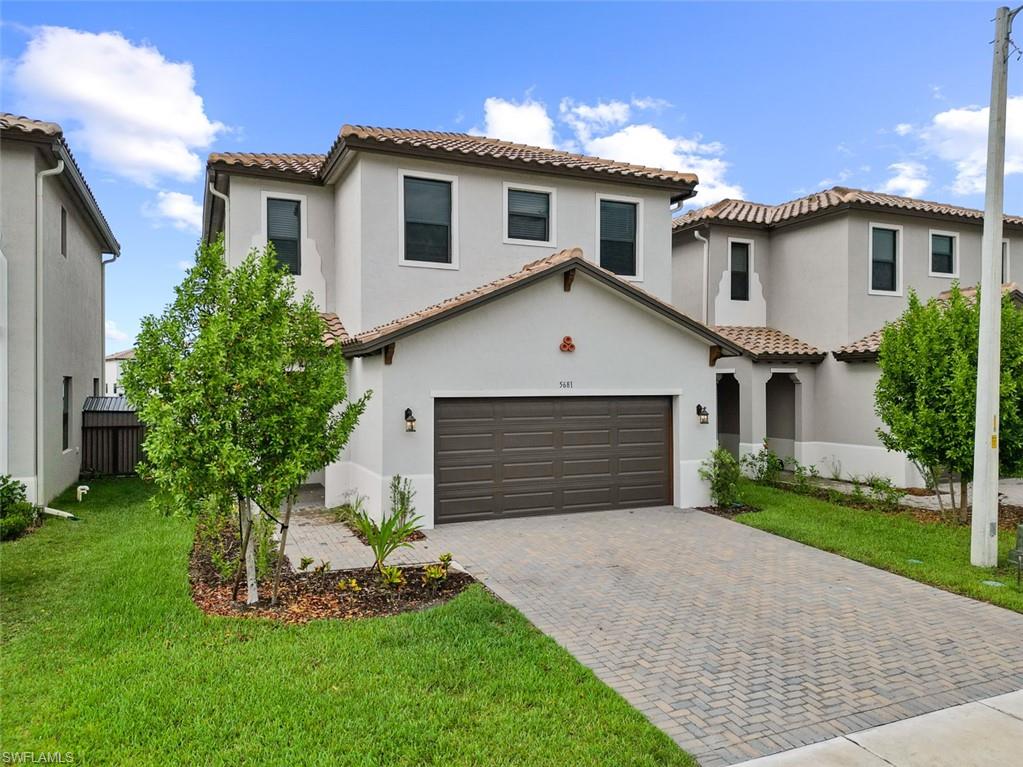 Mediterranean / spanish-style house featuring a garage and a front yard