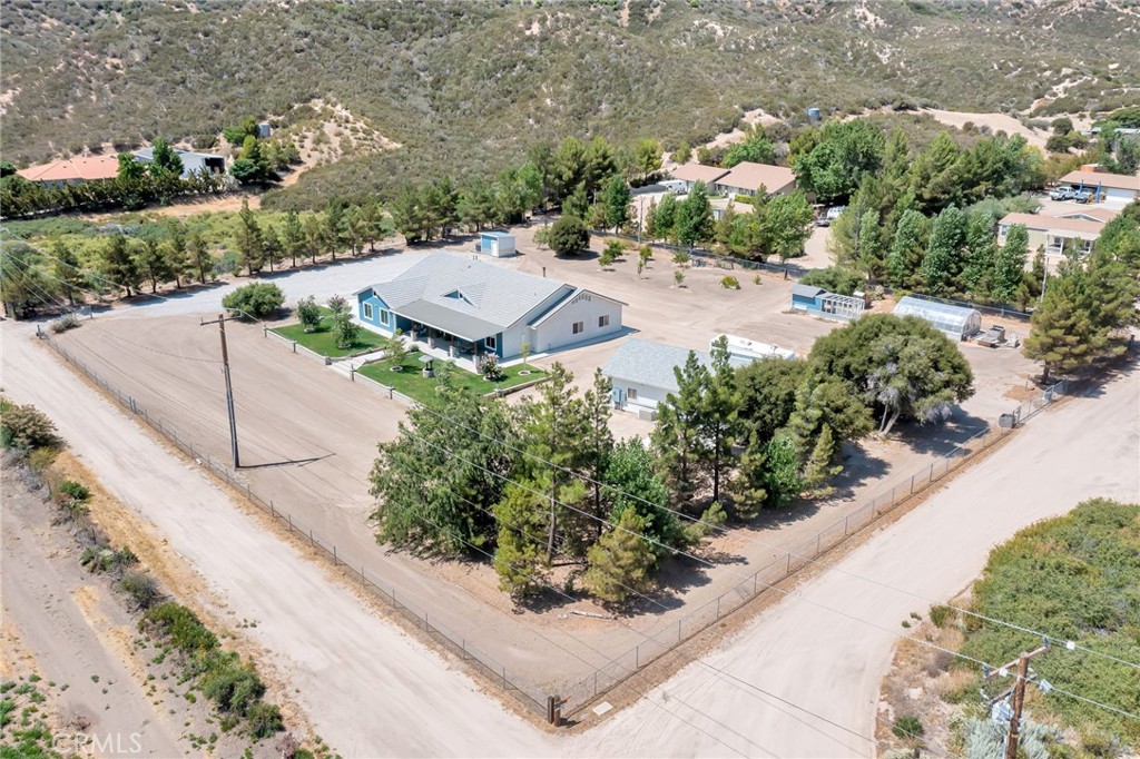 an aerial view of a house with a yard and tennis court